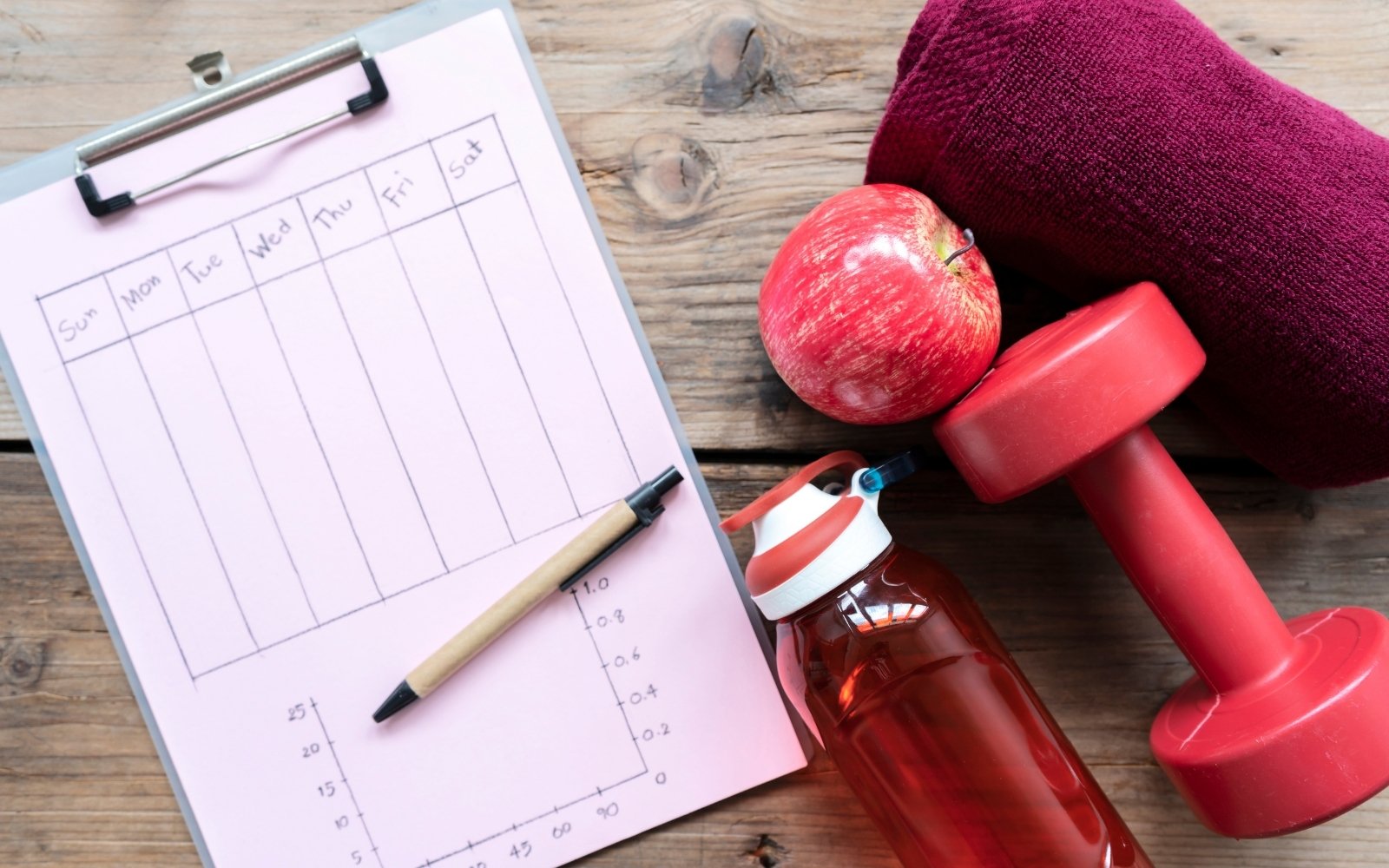 Fitness tracker, water bottle, weight, apple, and sweat towel