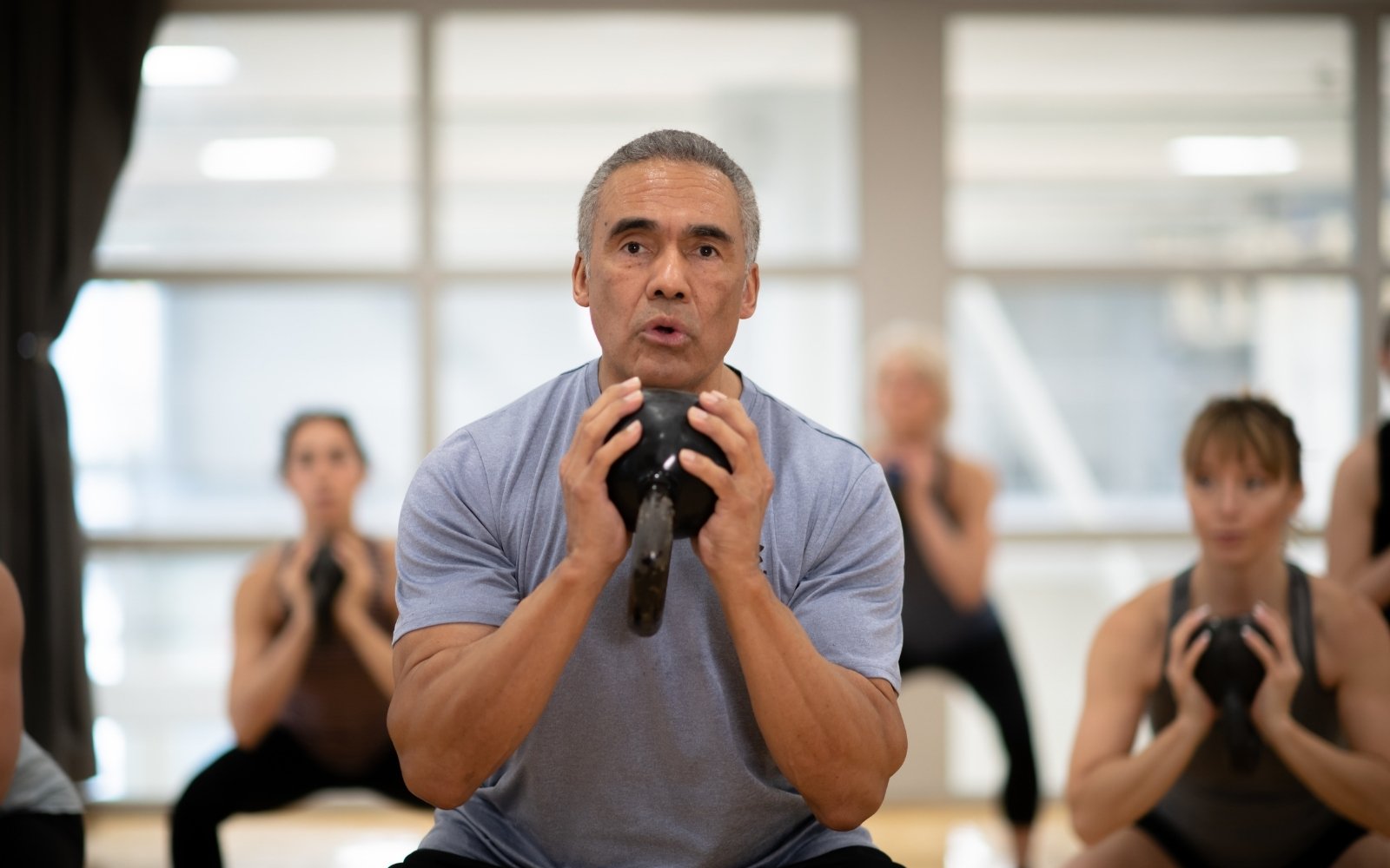 Man with kettlebell in exercise class