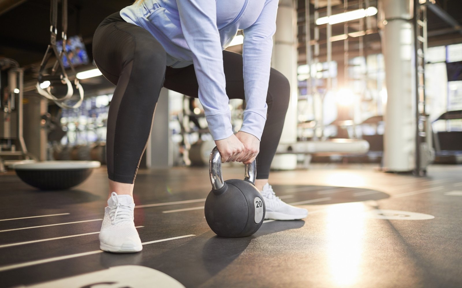 Person lifting kettlebell in gym